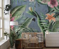 Large green floral leaves wallpaper mural with a blue backdrop.
