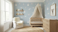 Forest Animals Blue wallpaper with white woodland critters behind an oak crib and canopy in a pale blue nursery