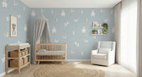 Forest Animals Blue wallpaper of bears and foxes behind a wood crib and white glider in a soft blue nursery