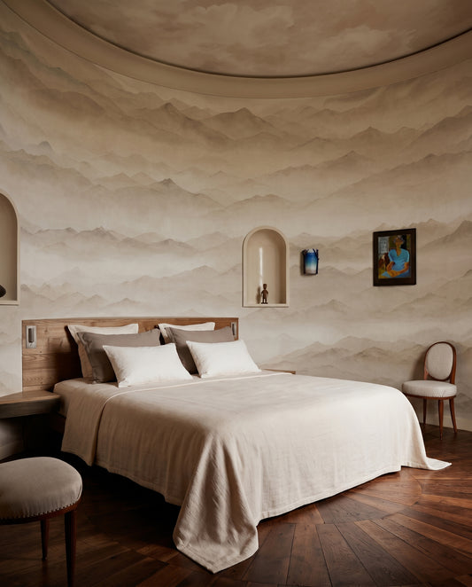 A hushed bedroom holds the Roerich Peaks wall mural in beige sepia mist.