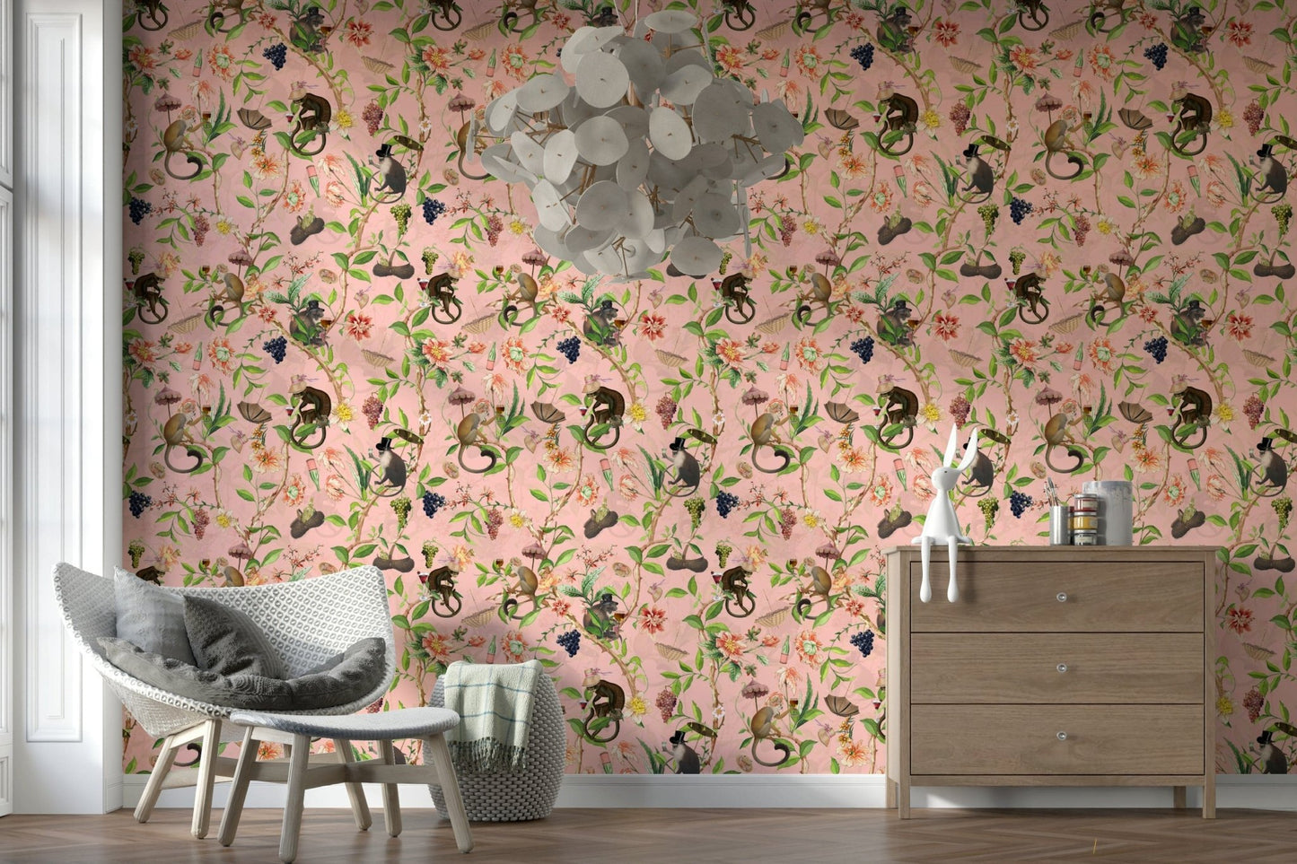 A Primate's Garden Party wallpaper of pink florals and monkeys with a rattan chair and wood dresser