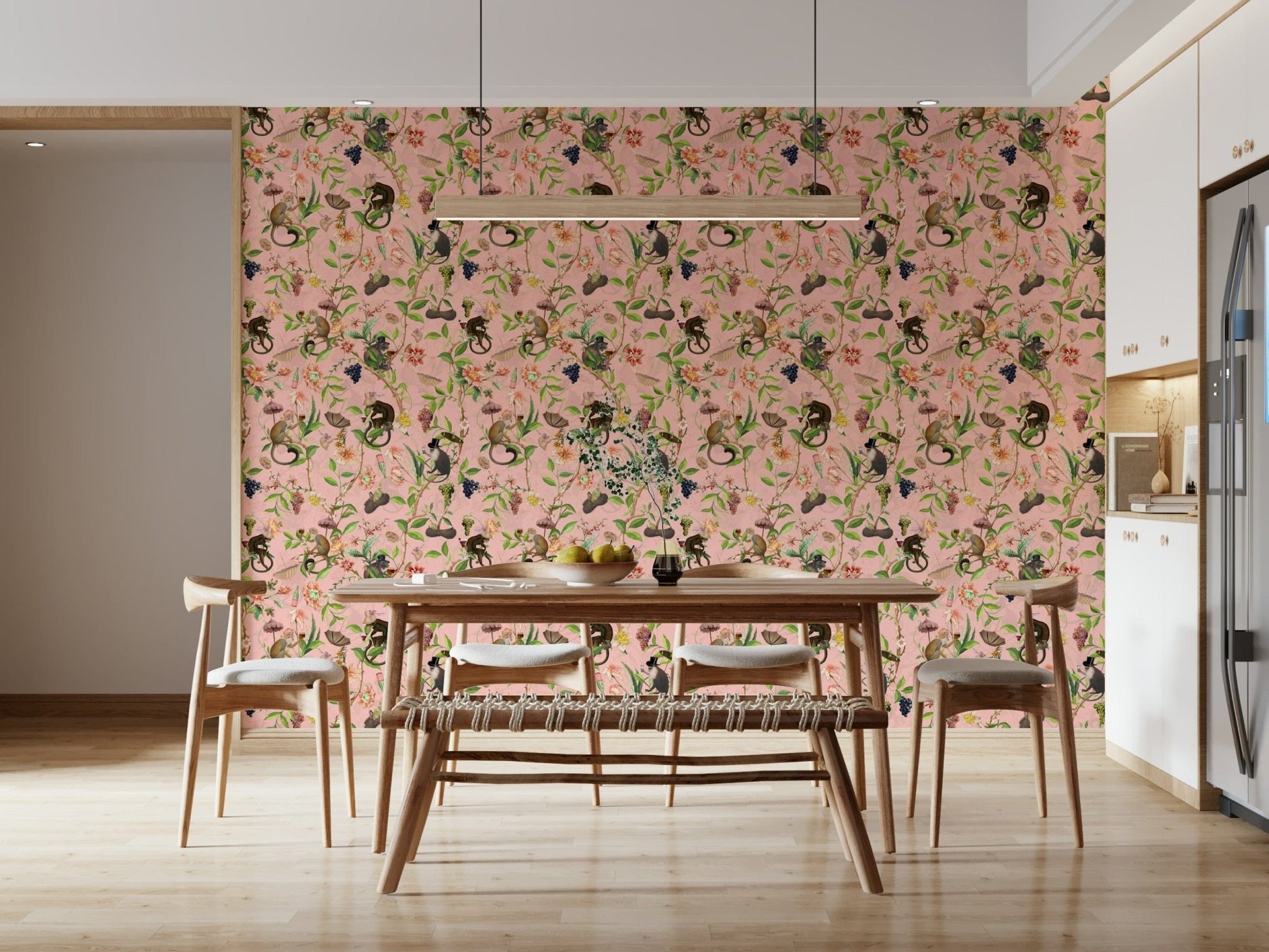 A Primate's Garden Party pink wallpaper behind a wooden dining table and bench with cane chairs