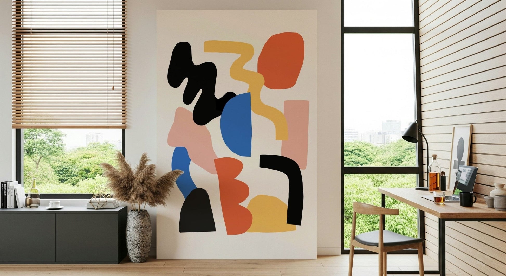 Abstract Block Party wall mural with black, orange and blue organic shapes on cream, above a wooden desk in a sunlit home office