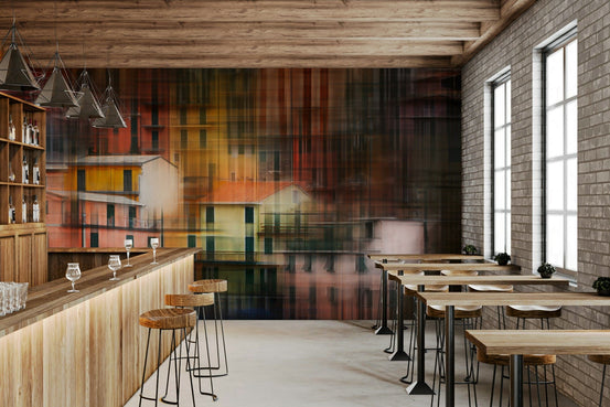 Abstract Cityscape wallpaper mural of warm-toned waterfront houses behind a wood bar with stools in a cafe interior