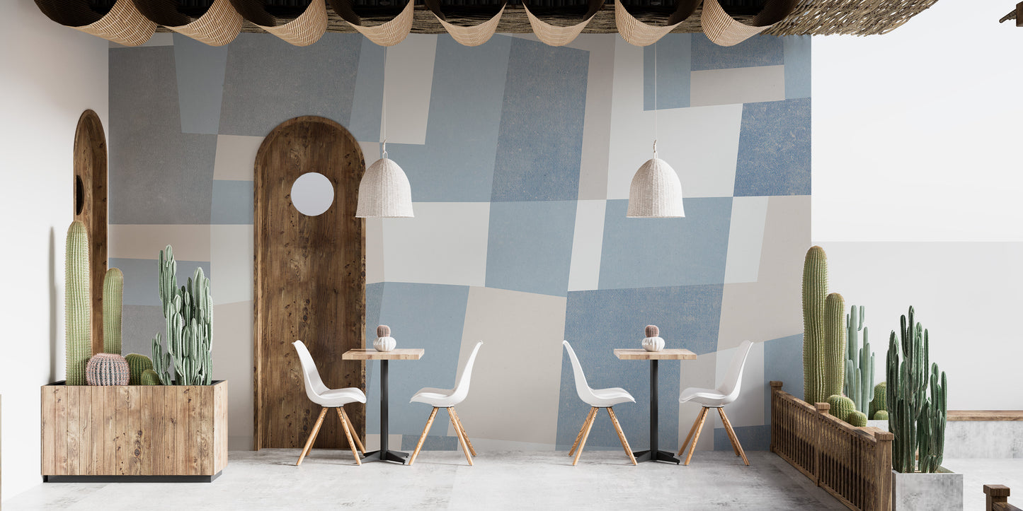 Abstract Cubist wallpaper mural in a cafe with white chairs, arched wood door and potted cacti