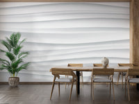 Abstract White Waves wallpaper mural of flowing white ridges behind a wooden dining table with a potted palm