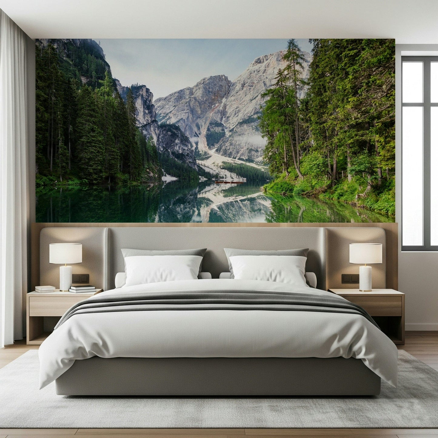 Alpine Reflections wallpaper mural of the mirrored mountain lake behind a grey upholstered bed in a calm bedroom
