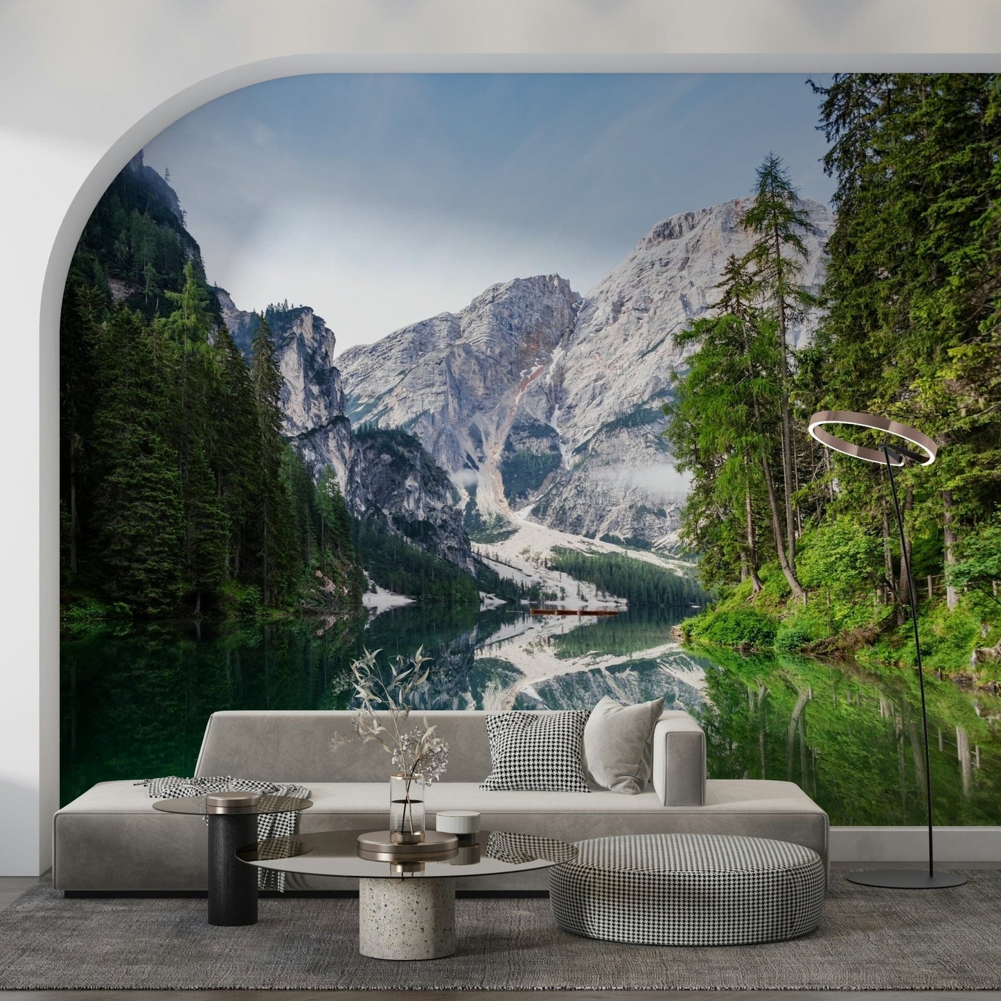 Alpine Reflections wallpaper mural of a mountain lake mirrored on emerald water behind a grey sofa in an arched living room