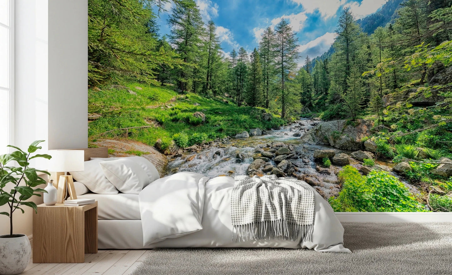 Alpine Stream wallpaper mural of a mountain creek behind a white bed with waffle throw in a bedroom