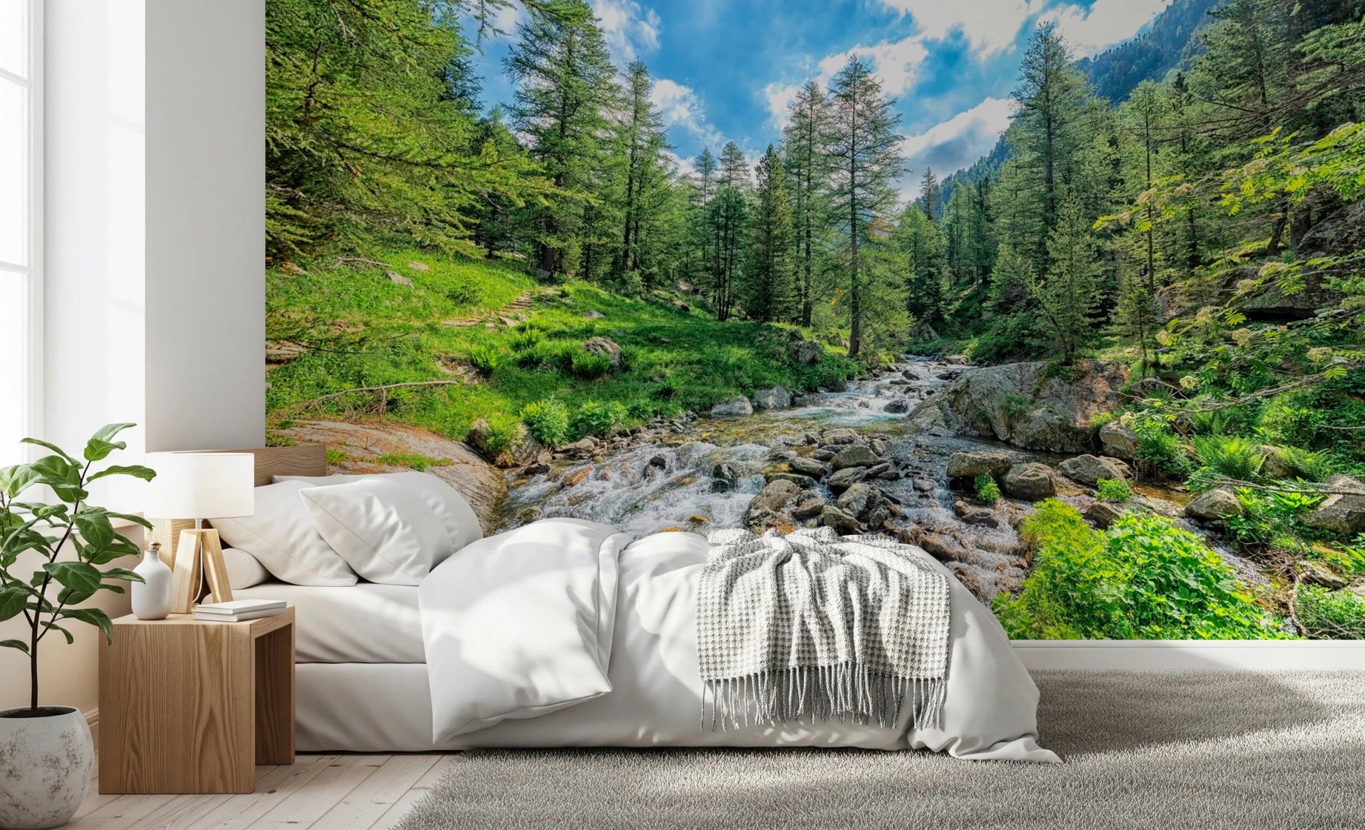 Alpine Stream wallpaper mural of a mountain creek behind a white bed with waffle throw in a bedroom