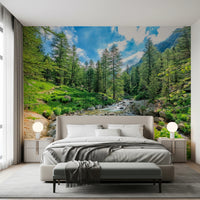 Alpine Stream wallpaper mural of a rocky mountain creek in a forest above a taupe bed in a bedroom