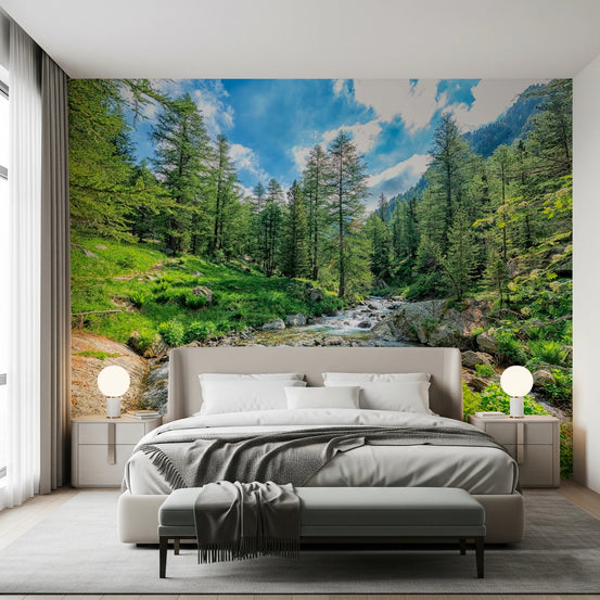 Alpine Stream wallpaper mural of a rocky mountain creek in a forest above a taupe bed in a bedroom