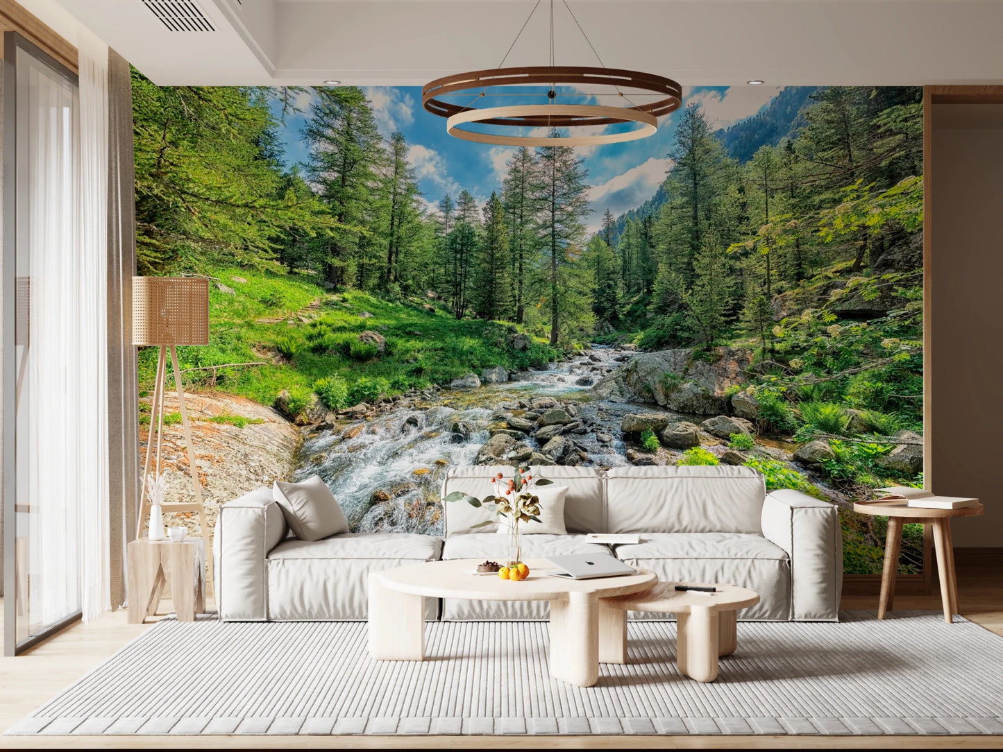 Alpine Stream wallpaper mural of a rocky creek in a forest behind a cream modular sofa in a living room