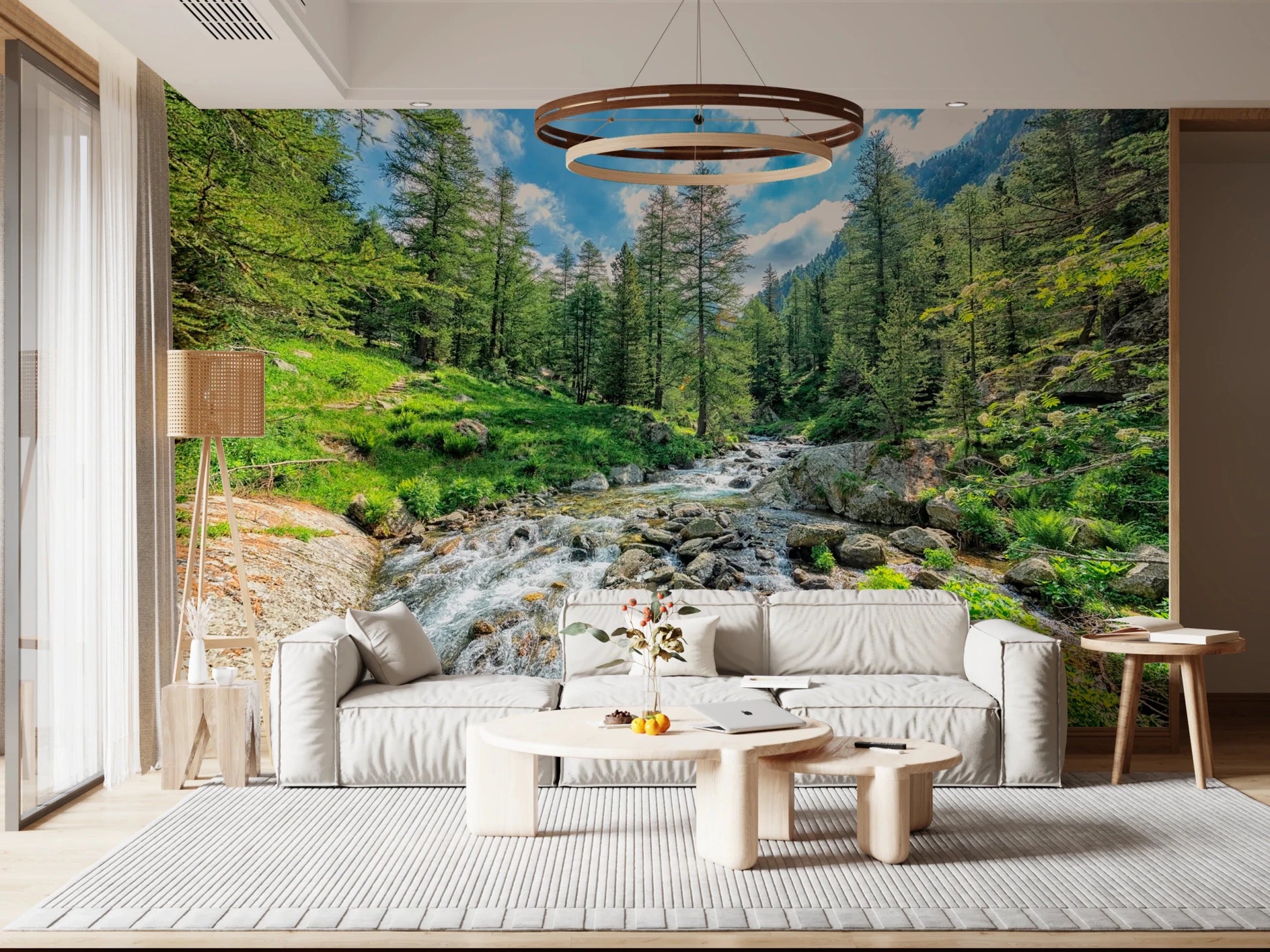 Alpine Stream wallpaper mural of a rocky creek in a forest behind a cream modular sofa in a living room