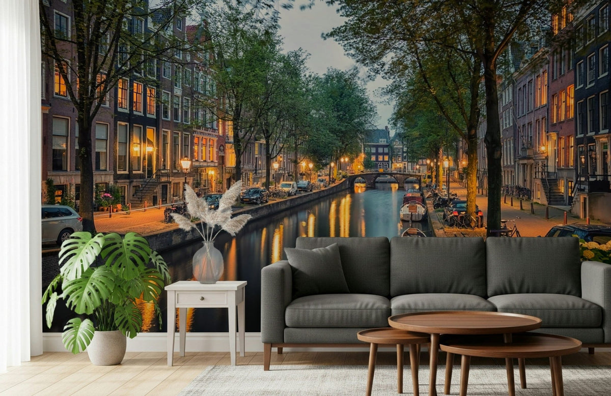 Amsterdam Canal Lights wallpaper mural of a dusk canal and townhouses behind a grey sofa in a living room