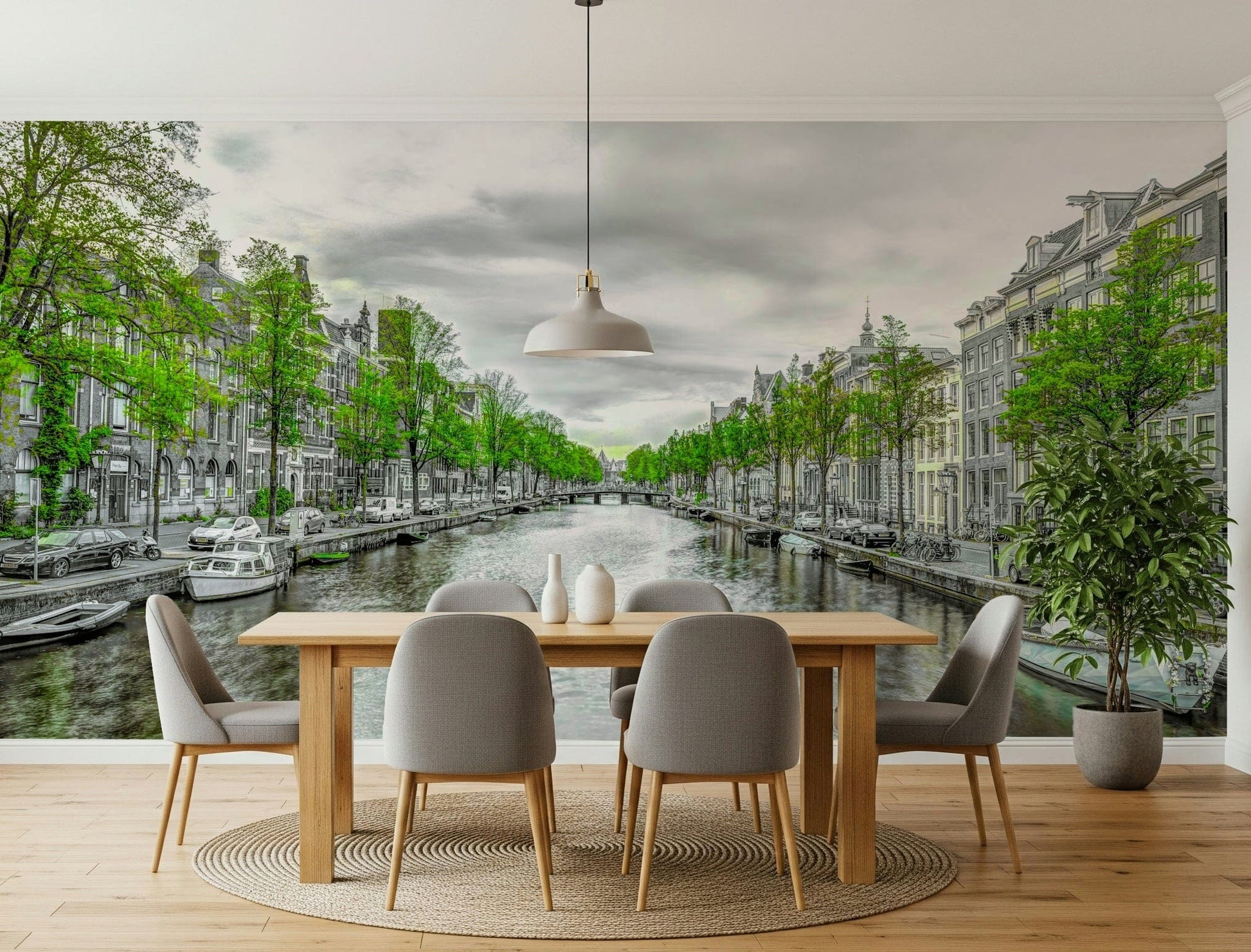 Amsterdam Canal Serenity wallpaper mural of a tree-lined canal and gray townhouses behind a wood dining table and gray chairs