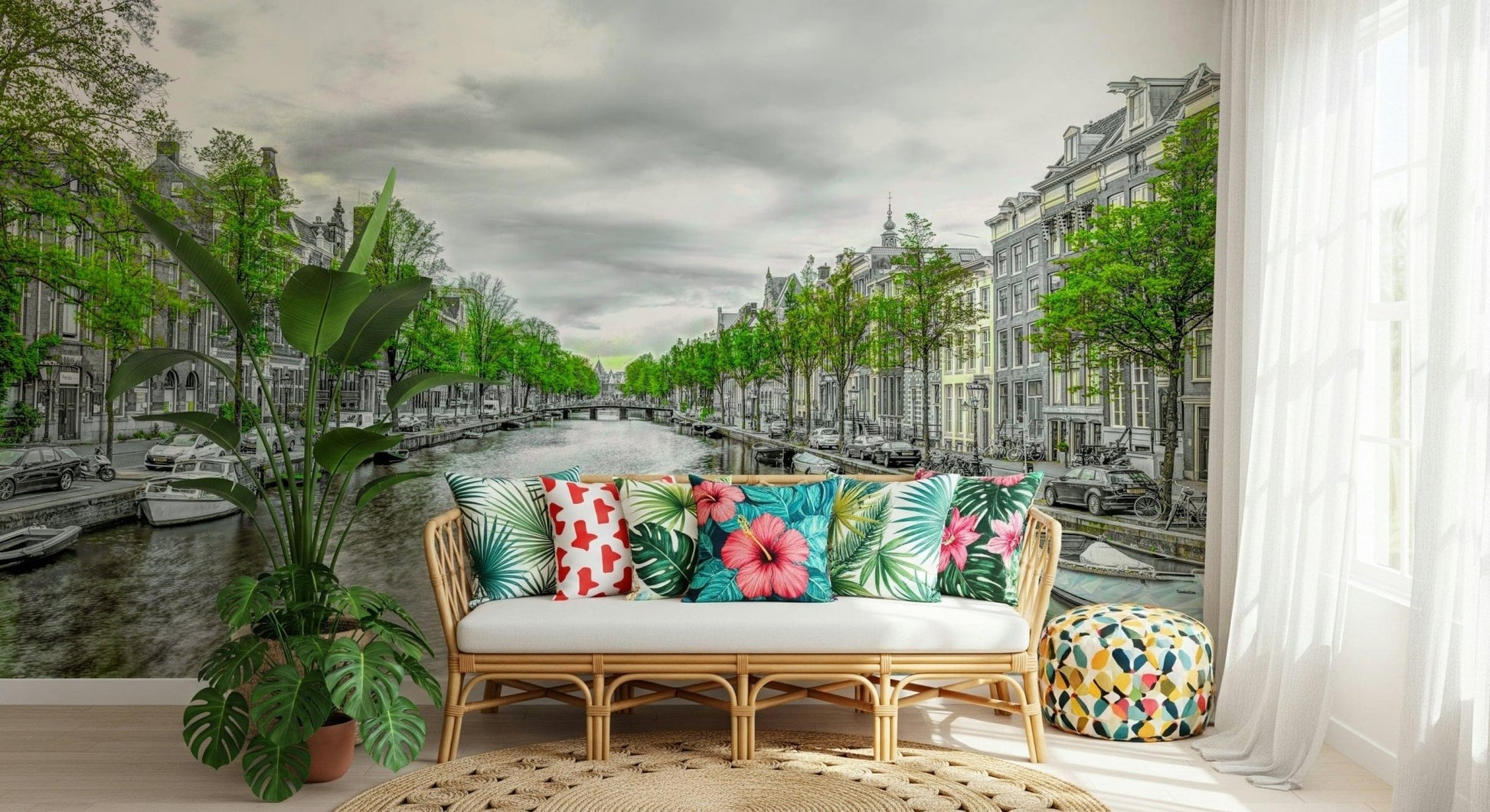 Amsterdam Canal Serenity wallpaper mural of a leafy canal behind a rattan sofa with tropical-print pillows in a sunroom