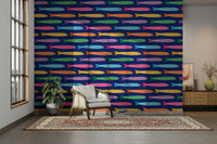 Playful anchovies fish wallpaper in rainbow shades on a deep blue backdrop.

