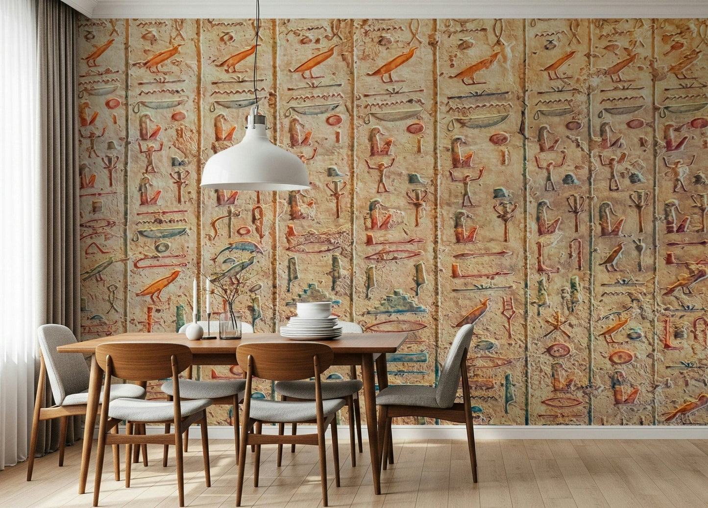 Ancient Glyphs wallpaper mural of hieroglyph columns behind a wood dining table and grey chairs in a dining room