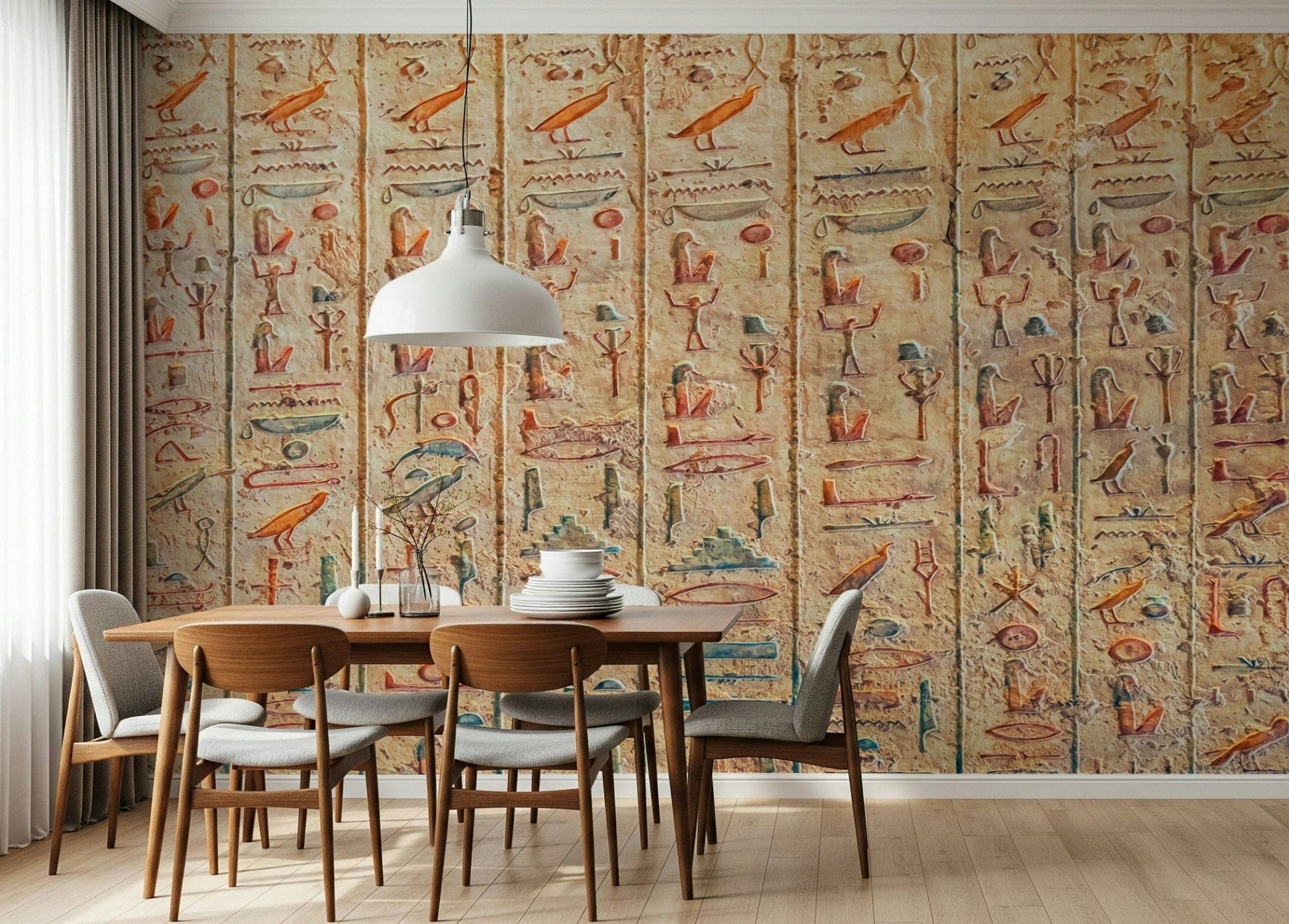 Ancient Glyphs wallpaper mural of hieroglyph columns behind a wood dining table and grey chairs in a dining room