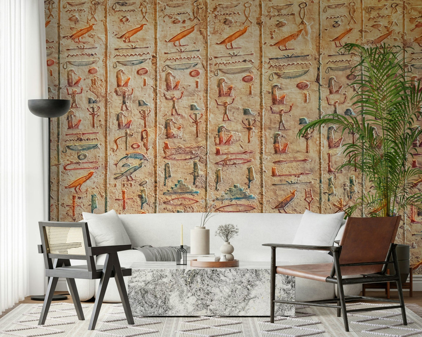 Ancient Glyphs wallpaper mural of stone hieroglyphs behind a white sofa and cane chairs in a living room