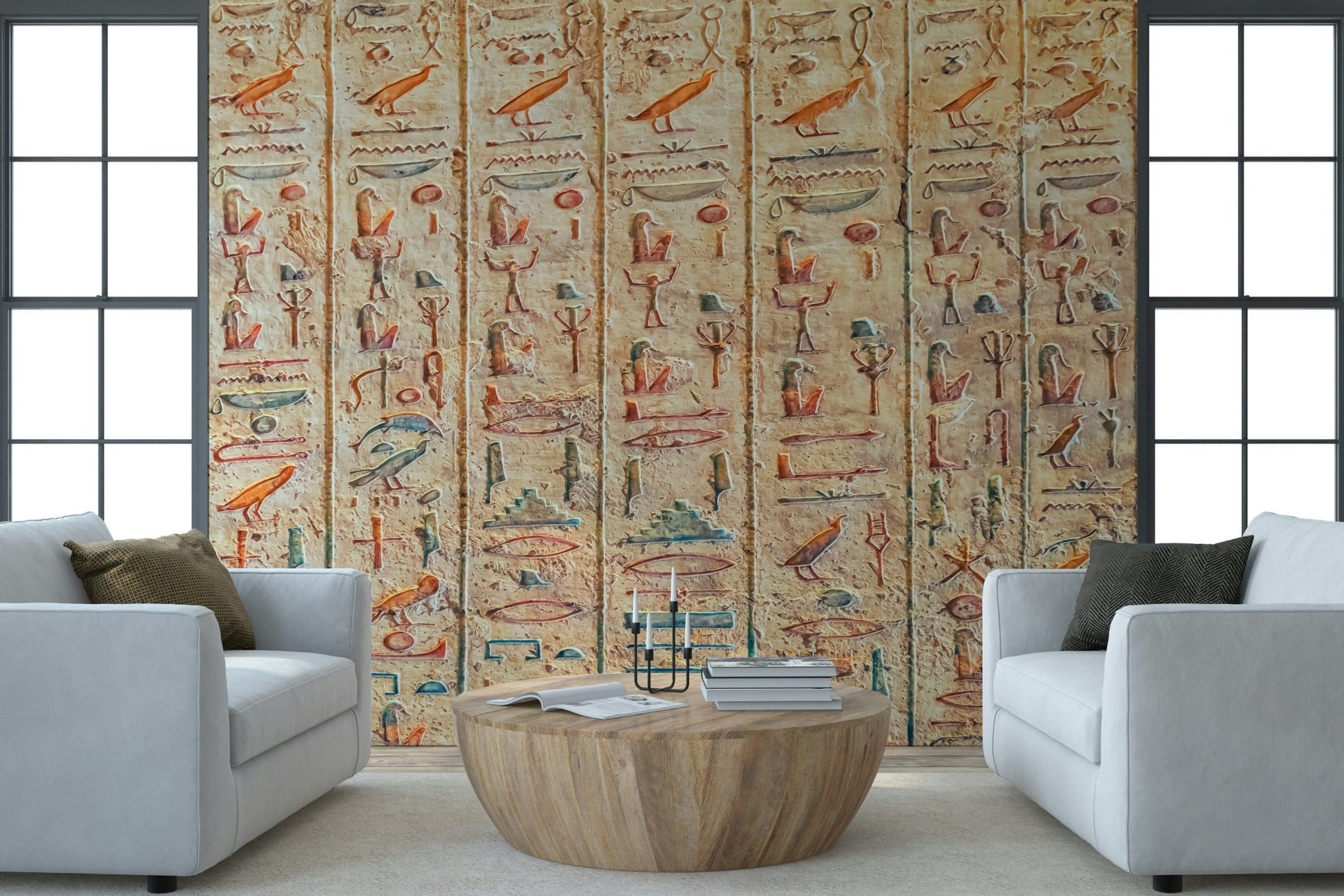 Ancient Glyphs wallpaper mural of Egyptian carvings between two white armchairs and a round wood table in a living room