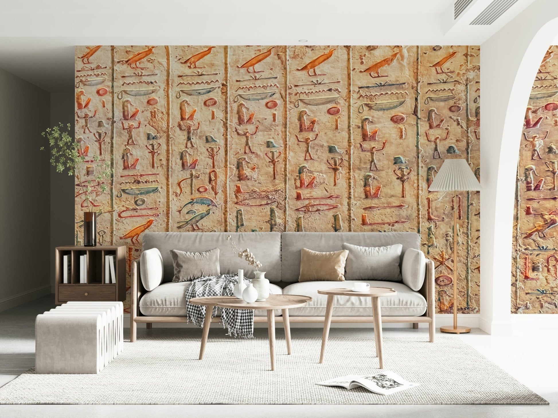 Ancient Glyphs wallpaper mural of carved Egyptian hieroglyphs behind a grey sofa in a bright living room