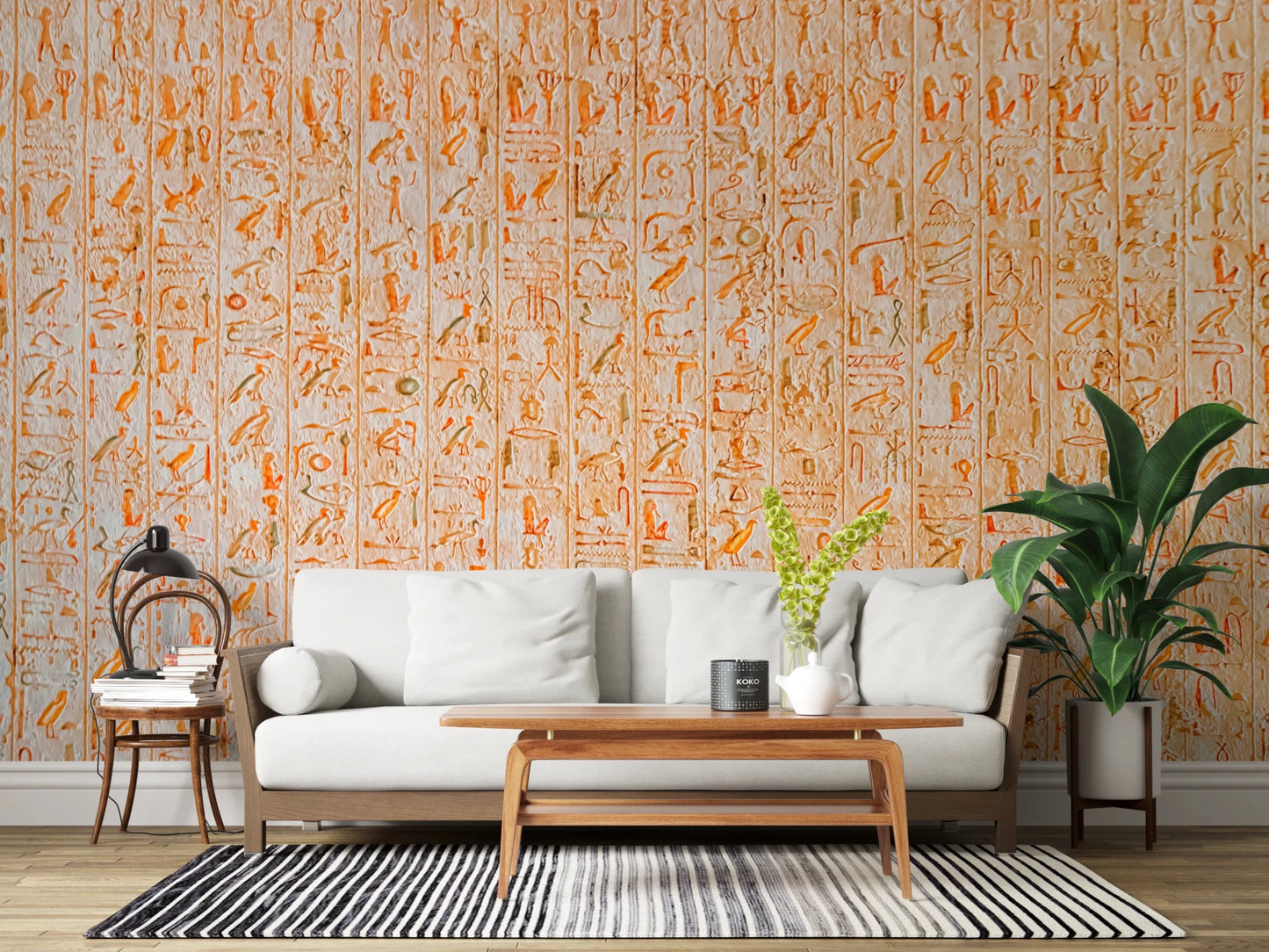 Ancient Inscriptions wallpaper mural in orange glyphs behind a white sofa and potted palm in a bright living room