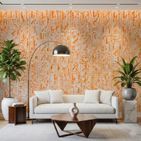 Ancient Inscriptions wallpaper mural in vivid orange behind a white sofa and arc floor lamp framed by two plants