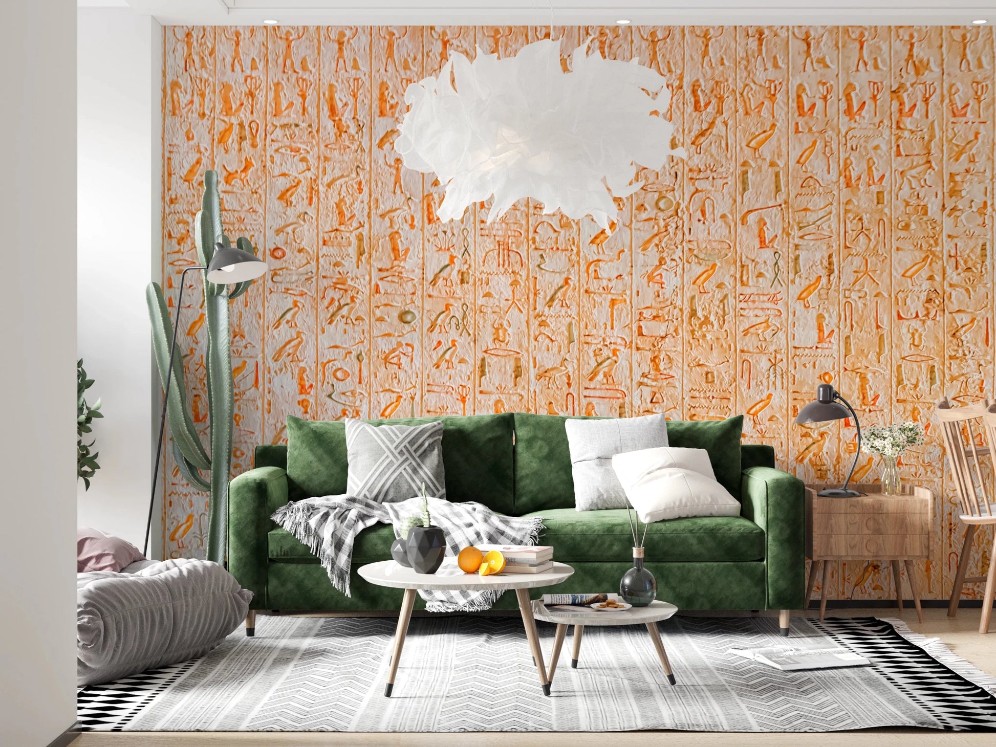 Ancient Inscriptions wallpaper mural in orange tones behind a green velvet sofa and feather pendant in a living room