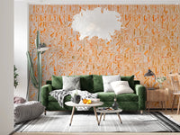 Ancient Inscriptions wallpaper mural in orange tones behind a green velvet sofa and feather pendant in a living room