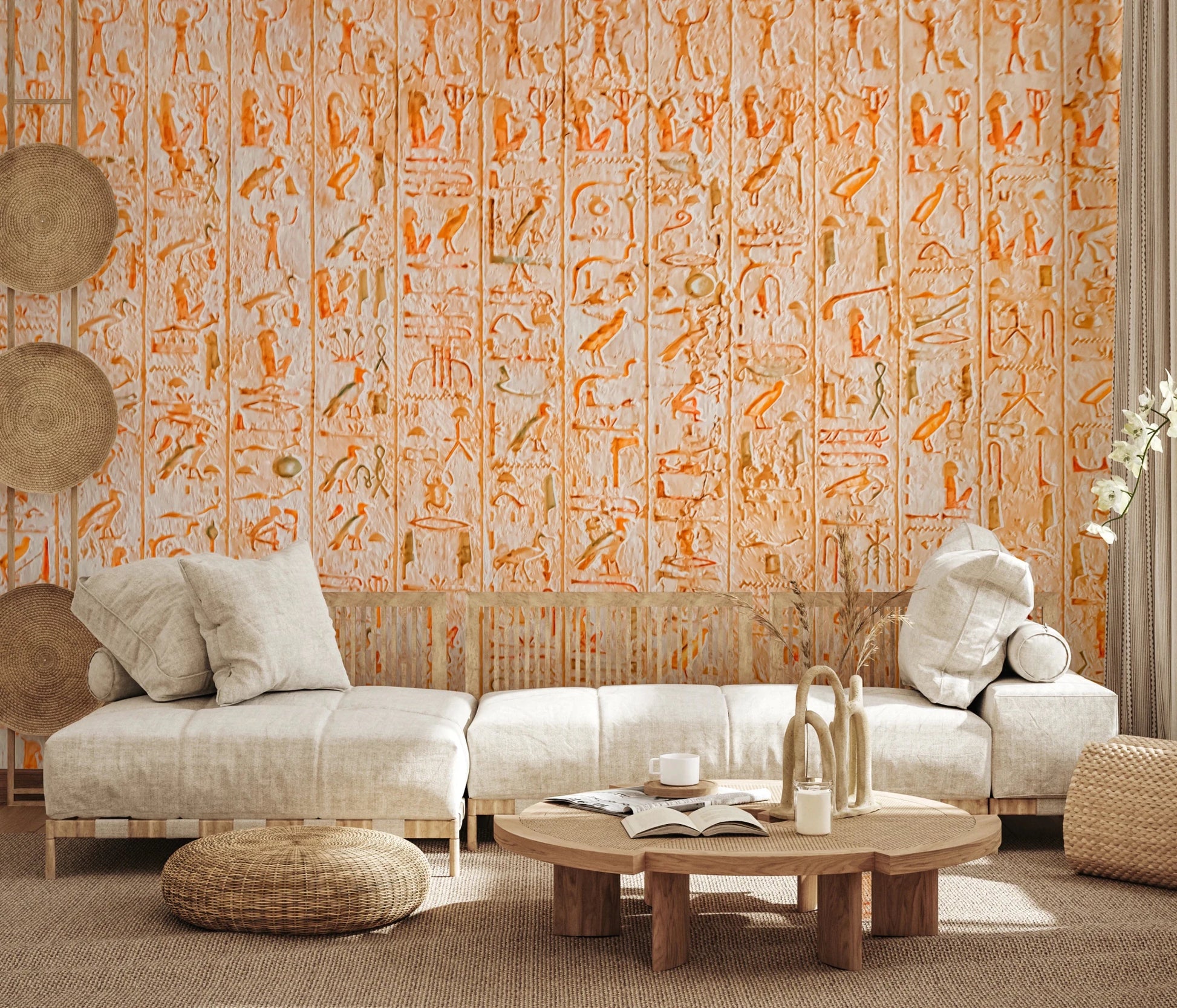 Ancient Inscriptions wallpaper mural in orange hieroglyphics behind an off-white sectional sofa in a sunlit living room