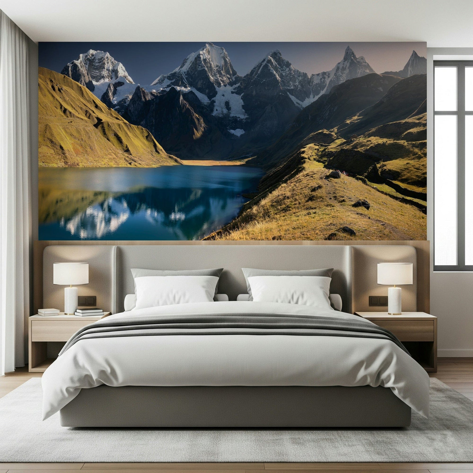 Andean Peaks & Serene Lake wallpaper mural of snowy peaks and a blue lake above a gray upholstered bed in a bedroom