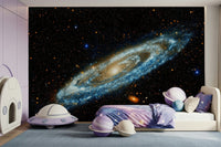 Andromeda galaxy mural in blue and gold above a lilac kids bed with planet bedding and a house play tent
