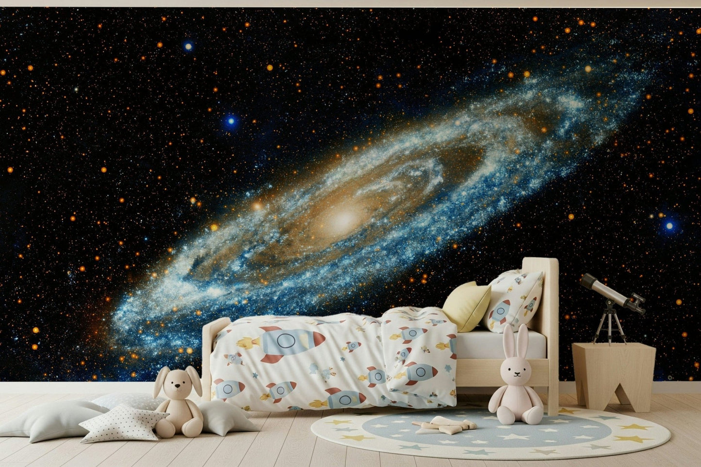 Andromeda galaxy mural in blue and gold above a wooden kids bed with rocket bedding and a telescope