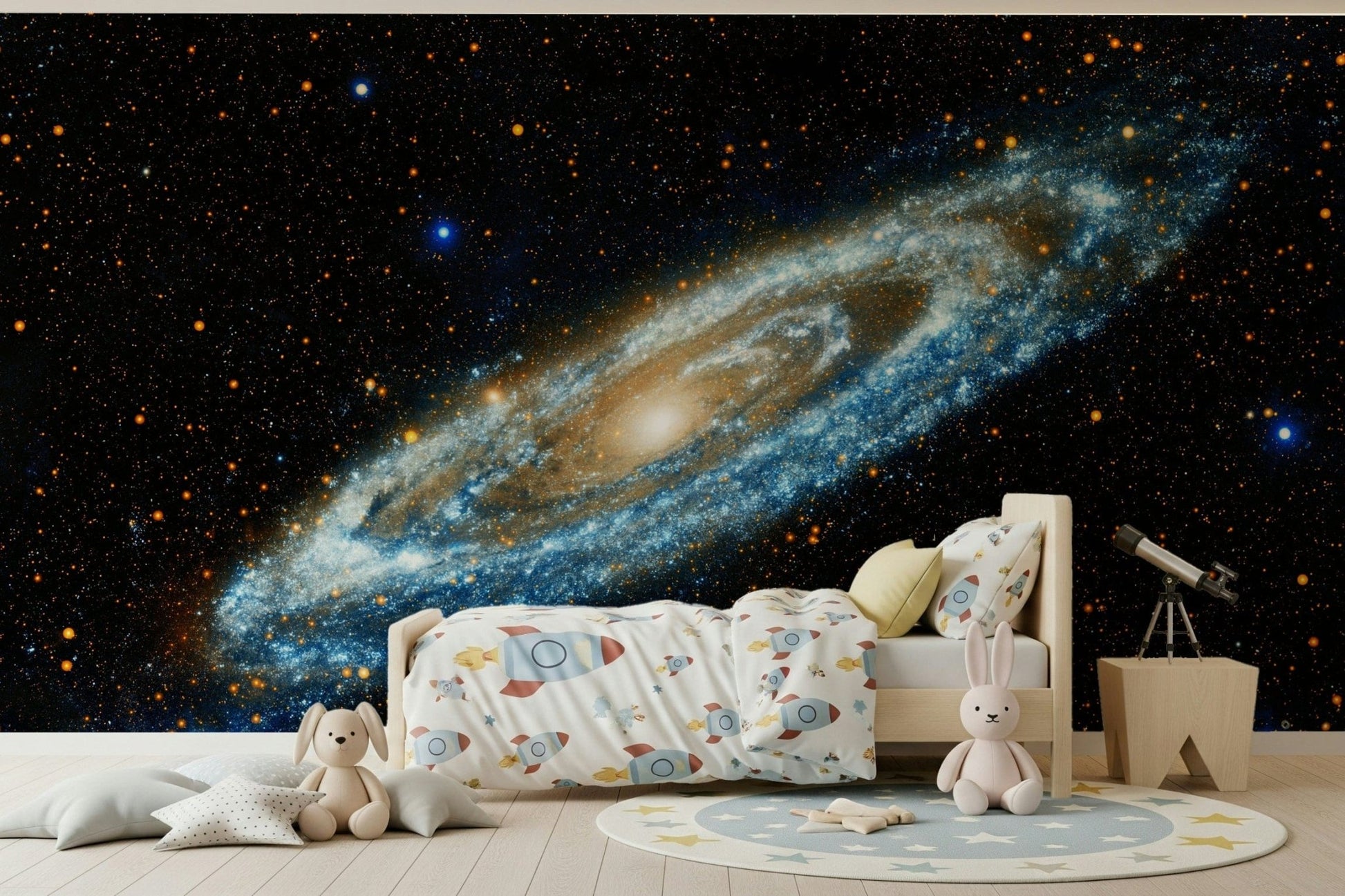 Andromeda galaxy mural in blue and gold above a wooden kids bed with rocket bedding and a telescope