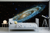Andromeda mural of a spiral galaxy on black behind a white star-print bed and a telescope