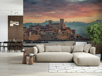 Dusk at Antibes wall mural featuring a historic seaside town glowing under a purple and peach sunset sky.