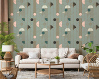 Art Deco Geometric Harmony wallpaper in green and gold deco pattern behind a cream sofa with rattan armchair