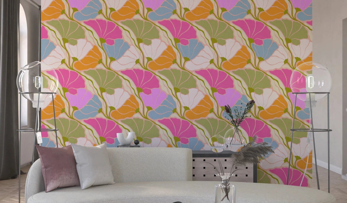 Art Nouveau Botanica Fan Flow Bloom Burst wallpaper in pink and orange florals behind a cream curved sofa