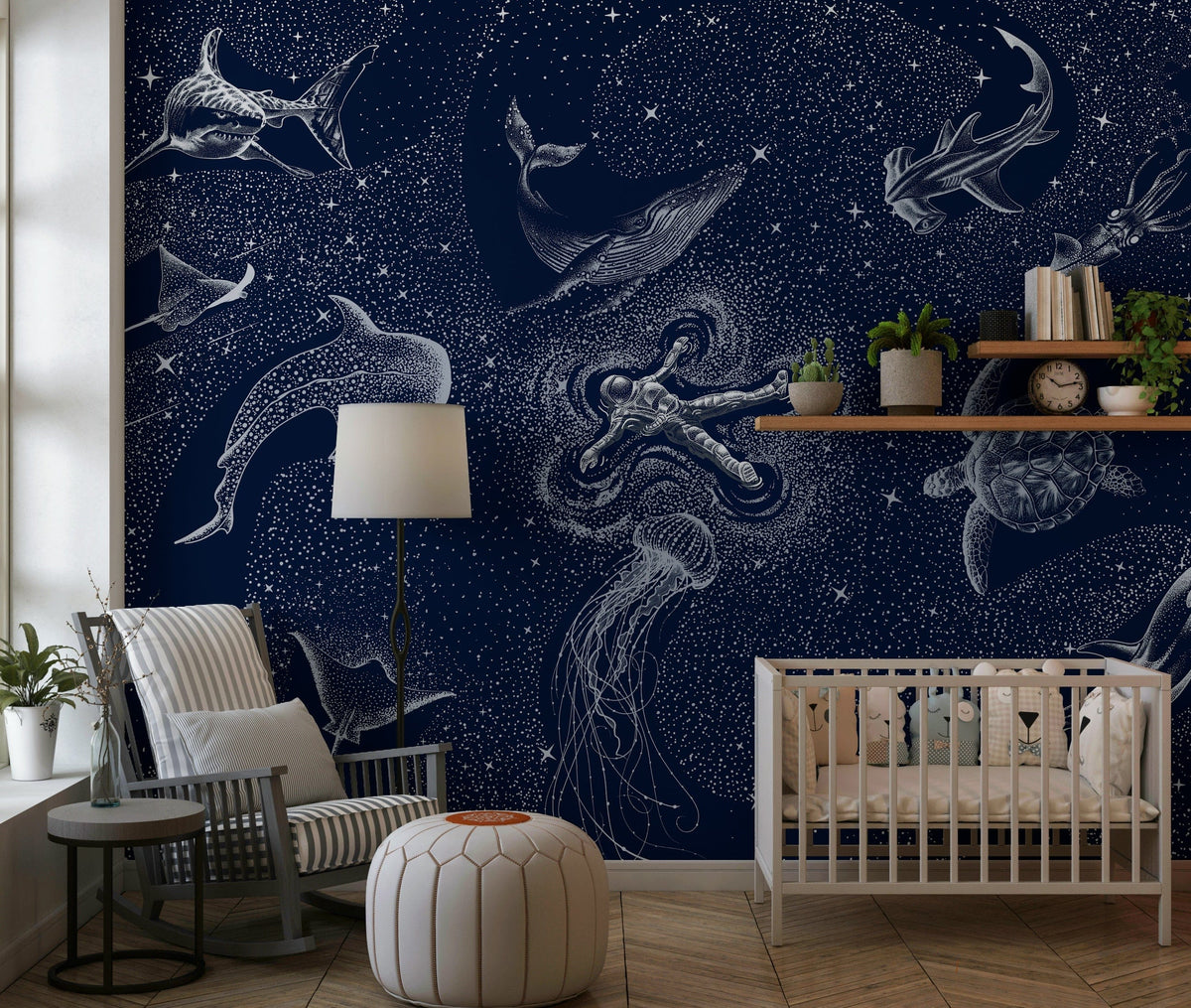 Astral Sea wallpaper mural with navy starry sky and white sea creatures behind a white crib and rocking chair in a nursery