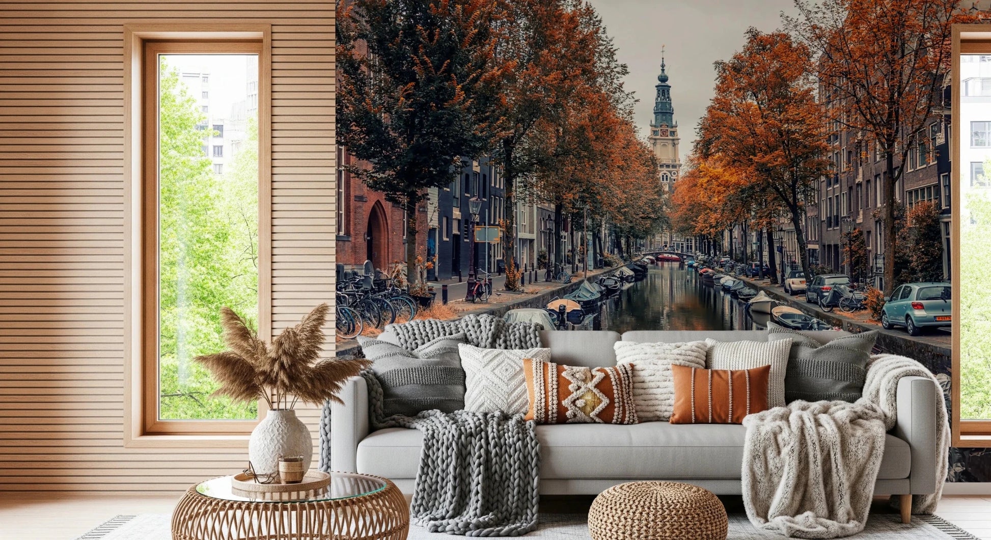 Autumn Canal Charm wallpaper mural of an autumn canal behind a grey sofa with boho pillows in a cozy living room