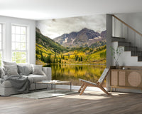 Dining area feature wall with autumn mountain lake wallpaper, wood table, warm light