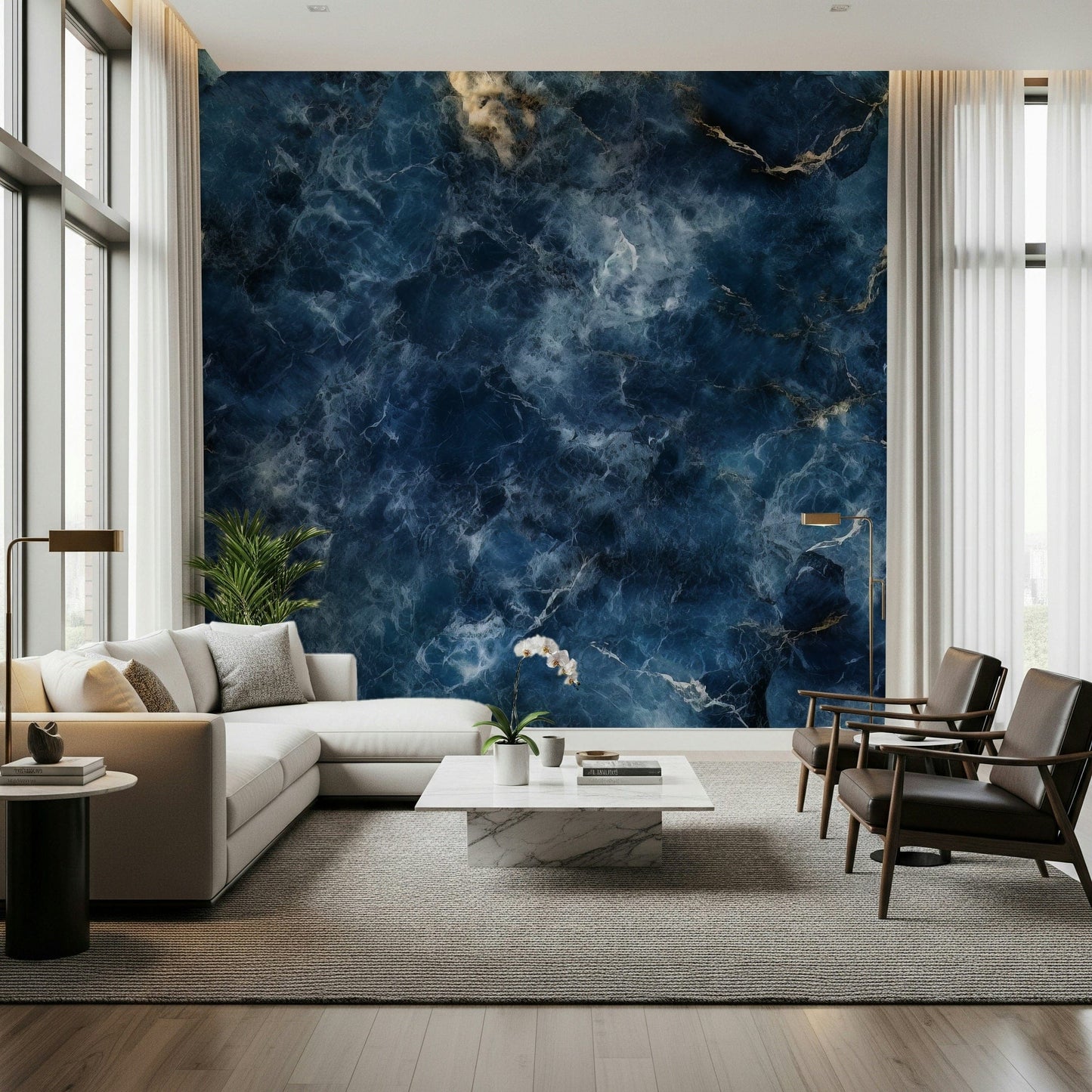 Azure Depths wallpaper mural of navy marble with gold veining behind a cream sectional sofa and leather armchairs in a living room
