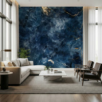 Azure Depths wallpaper mural of navy marble with gold veining behind a cream sectional sofa and leather armchairs in a living room