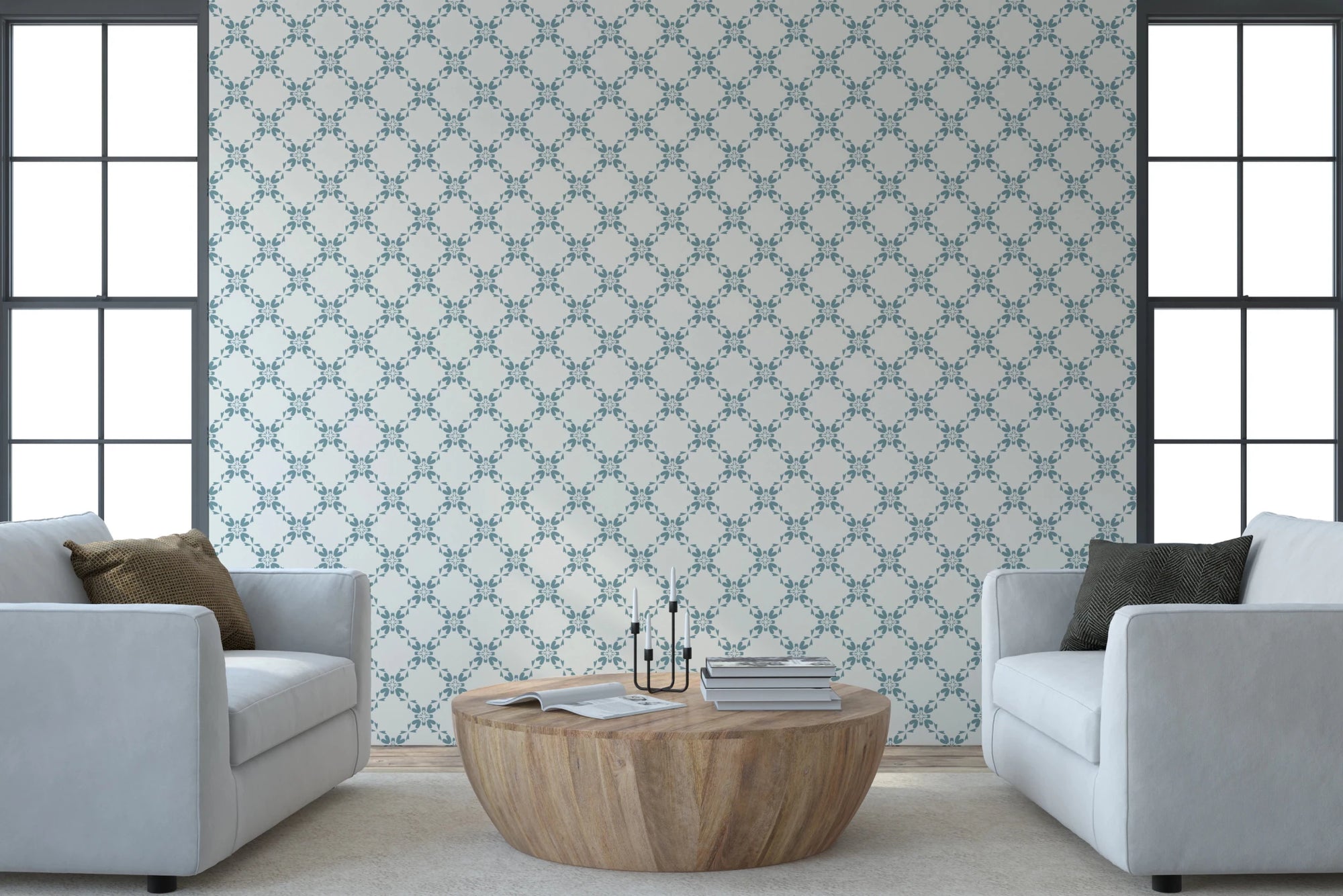 Azure Lattice wallpaper in teal and cream behind two pale grey sofas and a round wood coffee table in a bright living room