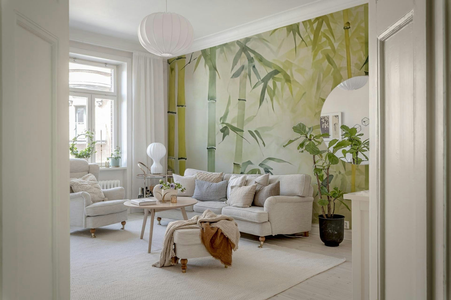 Bamboo Forest Serenity wallpaper mural in green behind a cream sofa and fiddle-leaf plant in a living room