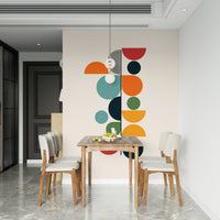 Bauhaus Spring wallpaper mural behind a wood dining table and cream chairs near a black door