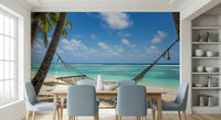 Beach Hammock Haven wallpaper mural of a beach hammock behind a wood dining table with pale blue chairs in a dining room