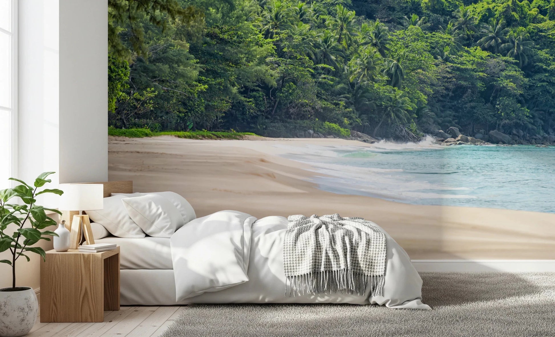 Beach Haven wall mural of a secluded beach and lush jungle behind a white bed and wood nightstand in a bedroom